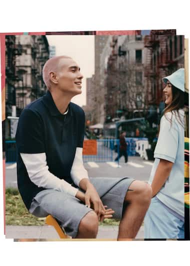 aposta na camisola pólo azul gasolina por baixo de uma camisola branca de manga comprida usada por Evan Mock